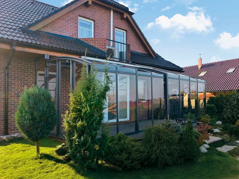 Terrassenüberdachung mit festem Aluminiumrahmen und Polycarbonat-Dach, komplett geschlossen bei bewölktem Himmel