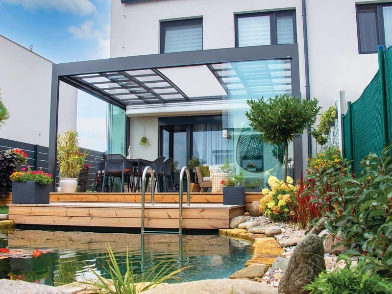 Bioklimatische Pergola mit verstellbarem Lamellendach über einer Terrasse mit Sitzmöbeln