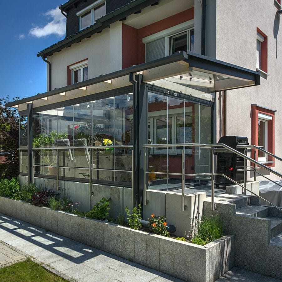 Terrassenüberdachung mit hochgeklappten Glasschiebeelementen und Edelstahlgeländer