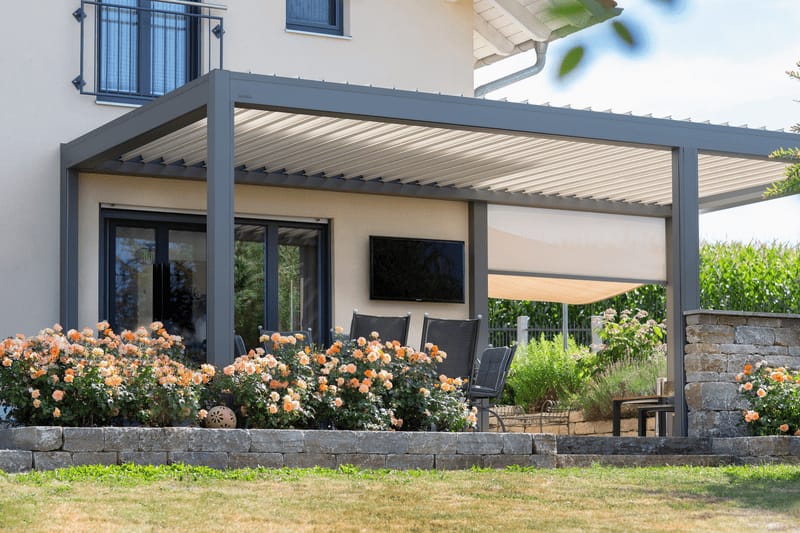 Terrasse an einem Einfamilienhaus mit Lamellendach und seitlich integriertem Sonnenschutz-Screen