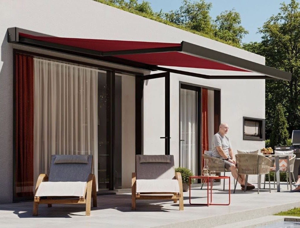 Kassettenmarkise mit farbigem, kräftig rotem Markisentuch an einer modernen Fassade