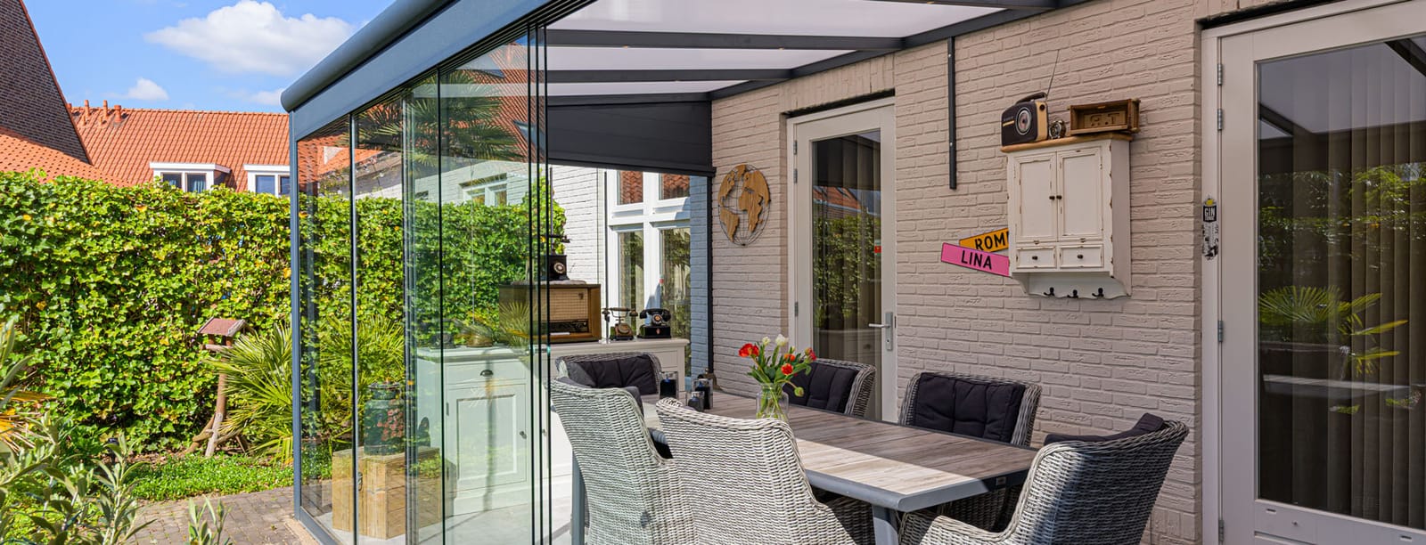 Gardendreams Essence Terrassenüberdachung mit Glasschiebewänden zum Gartenzimmer erweitert