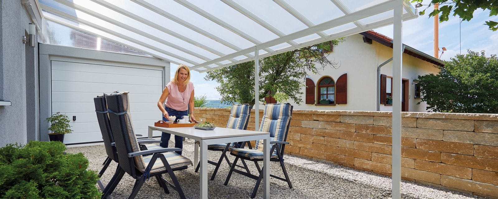 Weißes gutta Terrassendach Standard mit Polycarbonat-Eindeckung an einer Hausfassade montiert