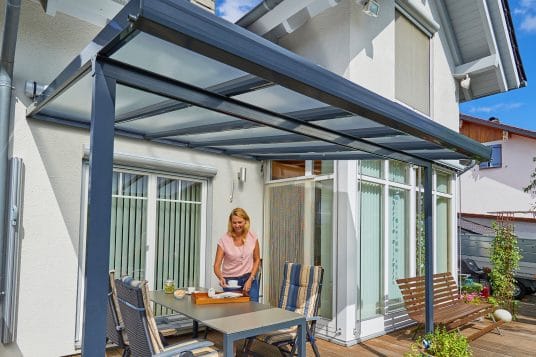 Quadratisches gutta Terrassendach in Anthrazit vor einem Einfamilienhaus