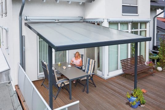 gutta Terrassendach in Anthrazit an einer Hauswand über einer Holzterrasse