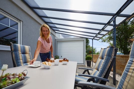 Anthrazitfarbenes gutta Terrassendach mit Aluminiumprofilen an einer Hausfassade