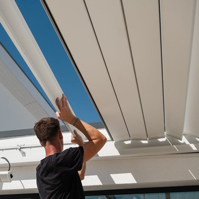 Handwerker montiert Pergolux-Dachlamellen im werkzeuglosen Klicksystem