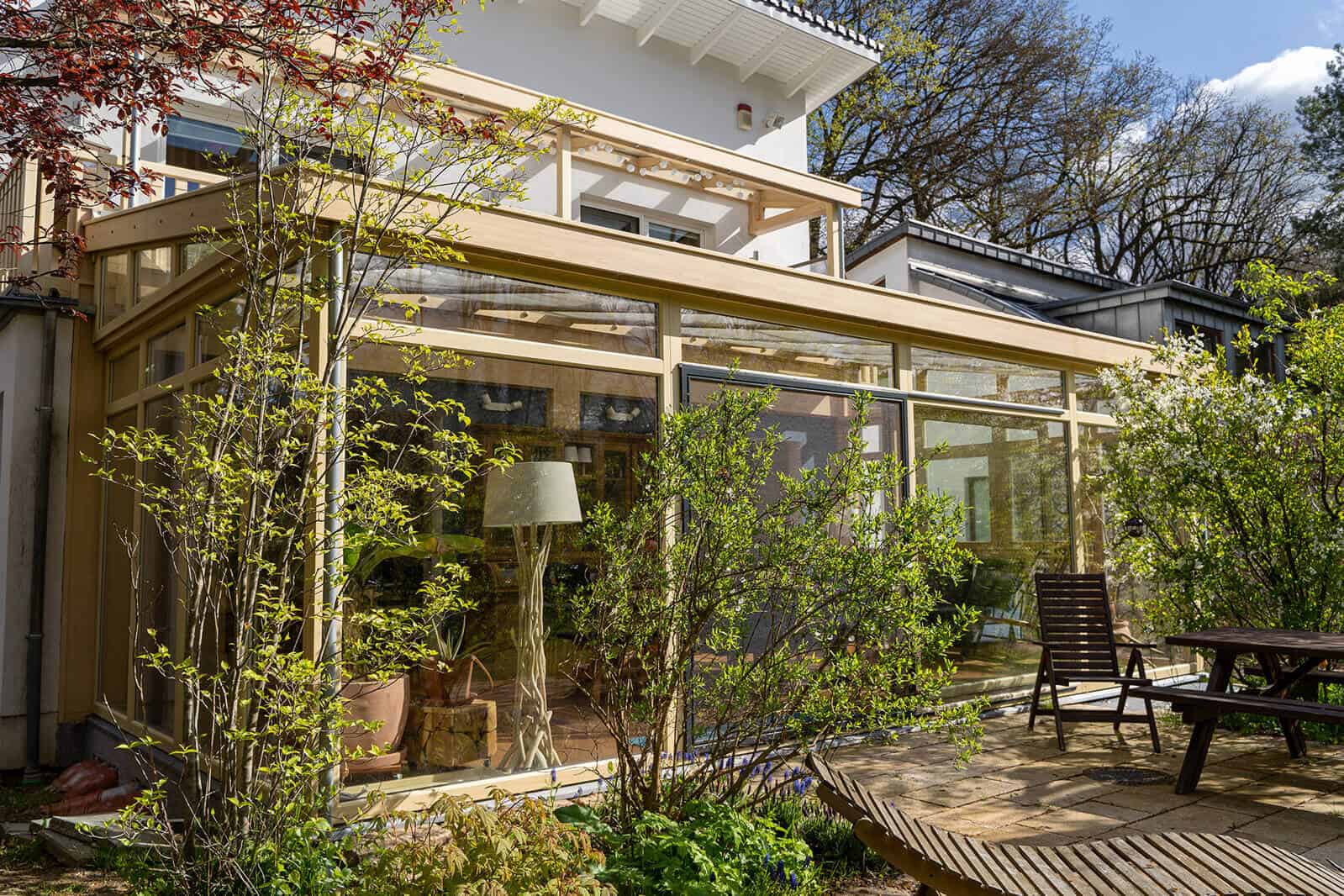 Wintergarten mit Holzkonstruktion und Pultdach am Einfamilienhaus, Terrasse mit Gartenmöbeln (Schennjesse)