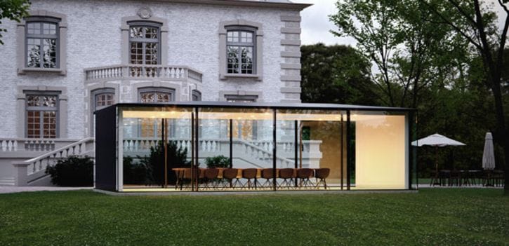 Gläserner Flachdach-Anbau mit raumhohen Glasfronten vor einer historischen Villa, Rasen im Vordergrund