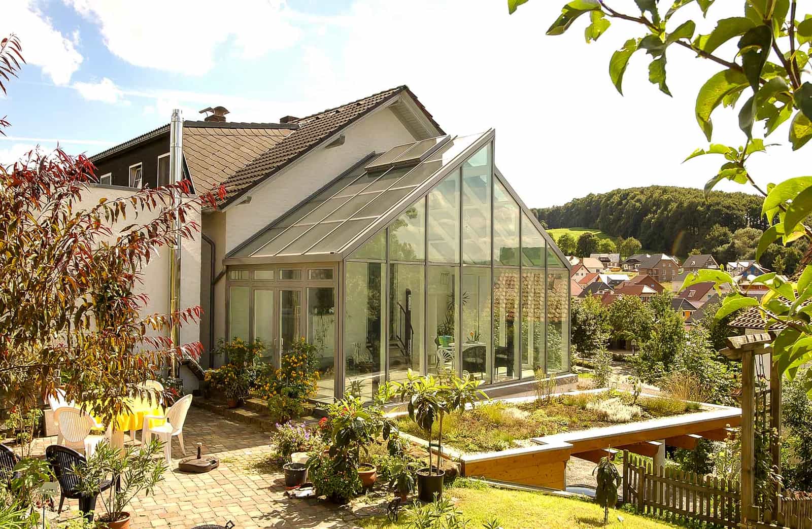 Sunshine FineArt Wintergarten mit Satteldach an einem Haus in Hanglage mit Panoramablick