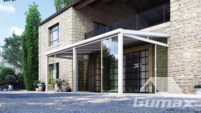 Weiße Terrassenüberdachung mit Glasschiebetüren an einem hellen Wohnhaus