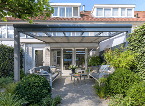 Terrassenüberdachung mit Glasdach und schlanken Aluminiumstützen an einem modernen Wohnhaus