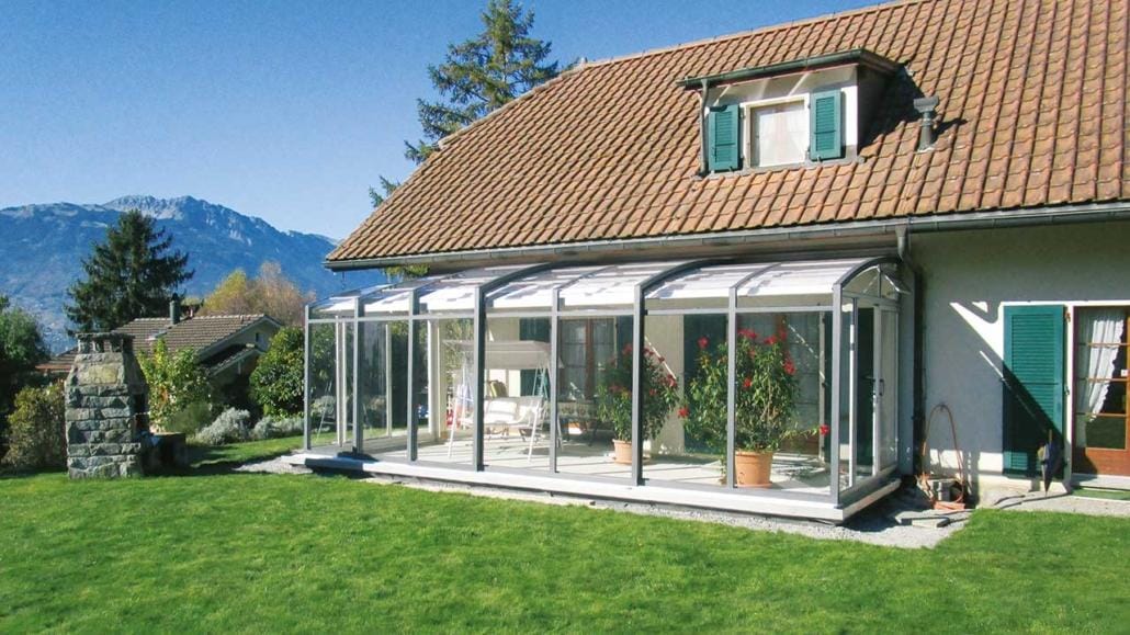 Schiebbare Terrassenüberdachung TOPAS Solar Veranda an einem Haus mit Bergpanorama