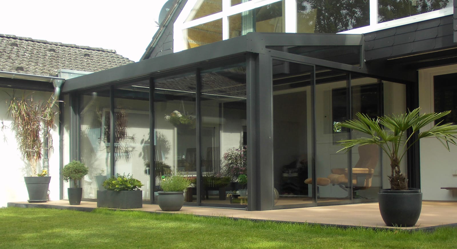 Wipro Sommergarten Plus Glashaus von außen an einem Wohnhaus mit Terrasse